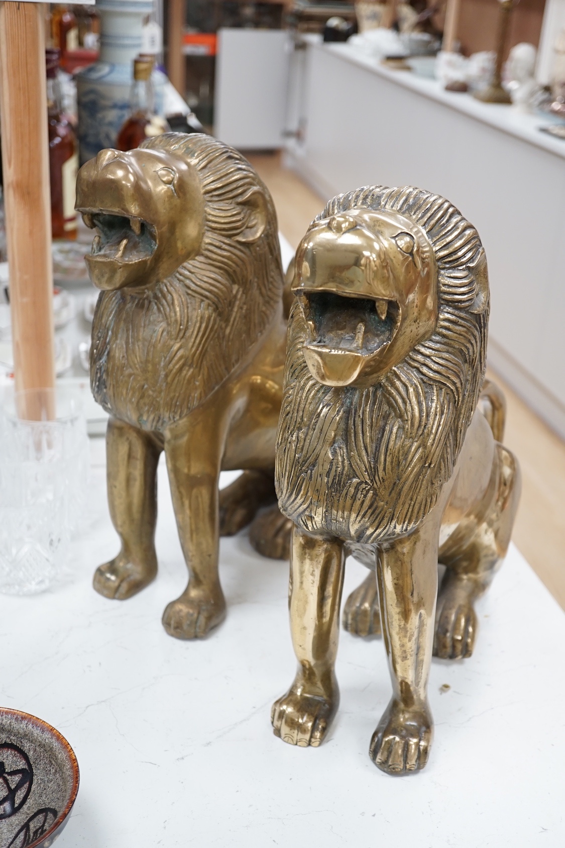 A pair of large brass lion models. 39cm
